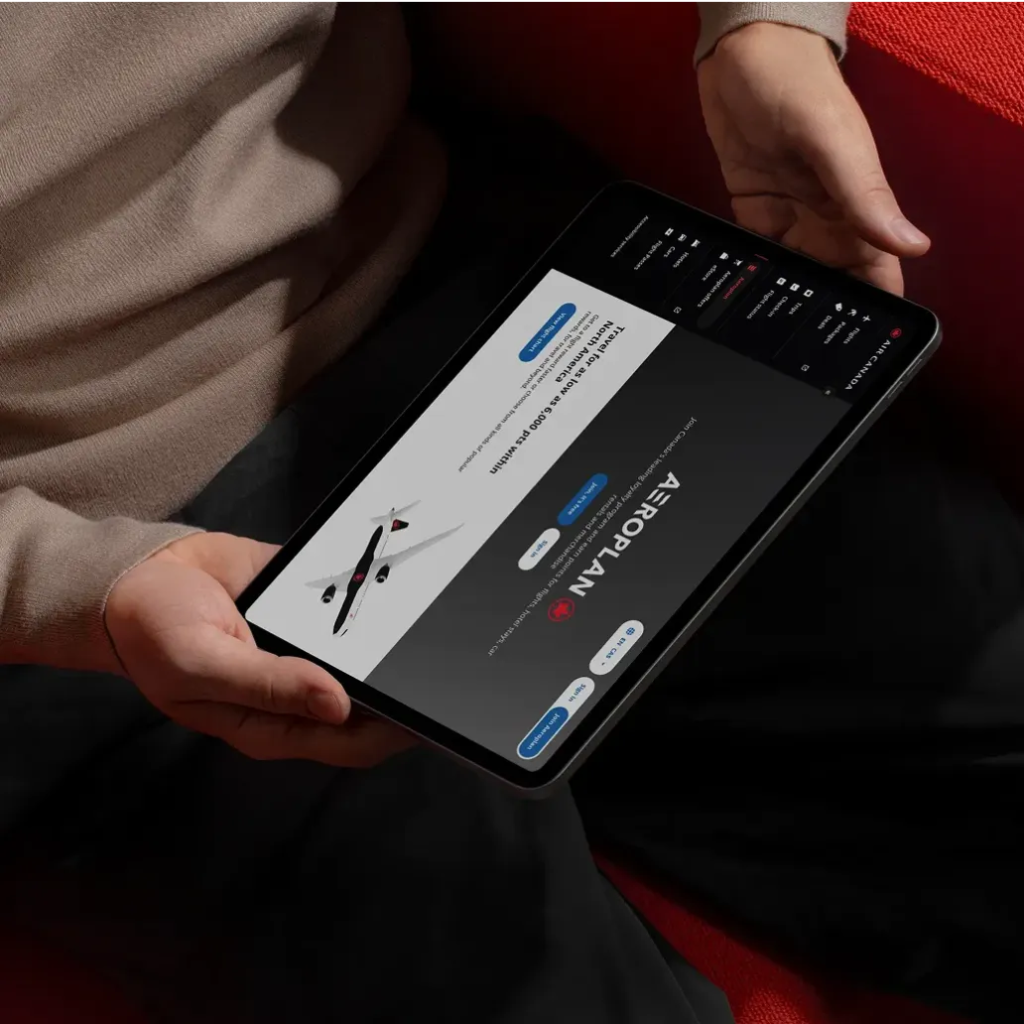 Person holding a tablet displaying a flight booking website with an airplane graphic.