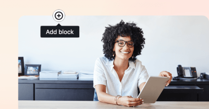 Smiling woman with curly hair holding a tablet, adding content on a digital solution.