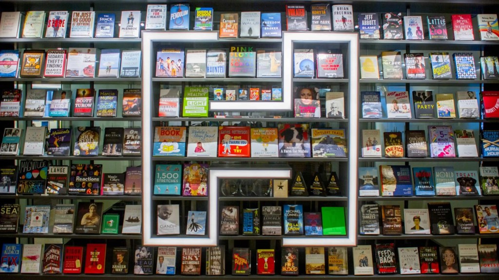Rows and rows of books on display with a large "H" built into the bookshelf to represent the Hachette Book Group Logo