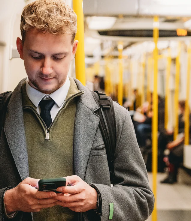Person using a mobile phone while travelling on public transportation.