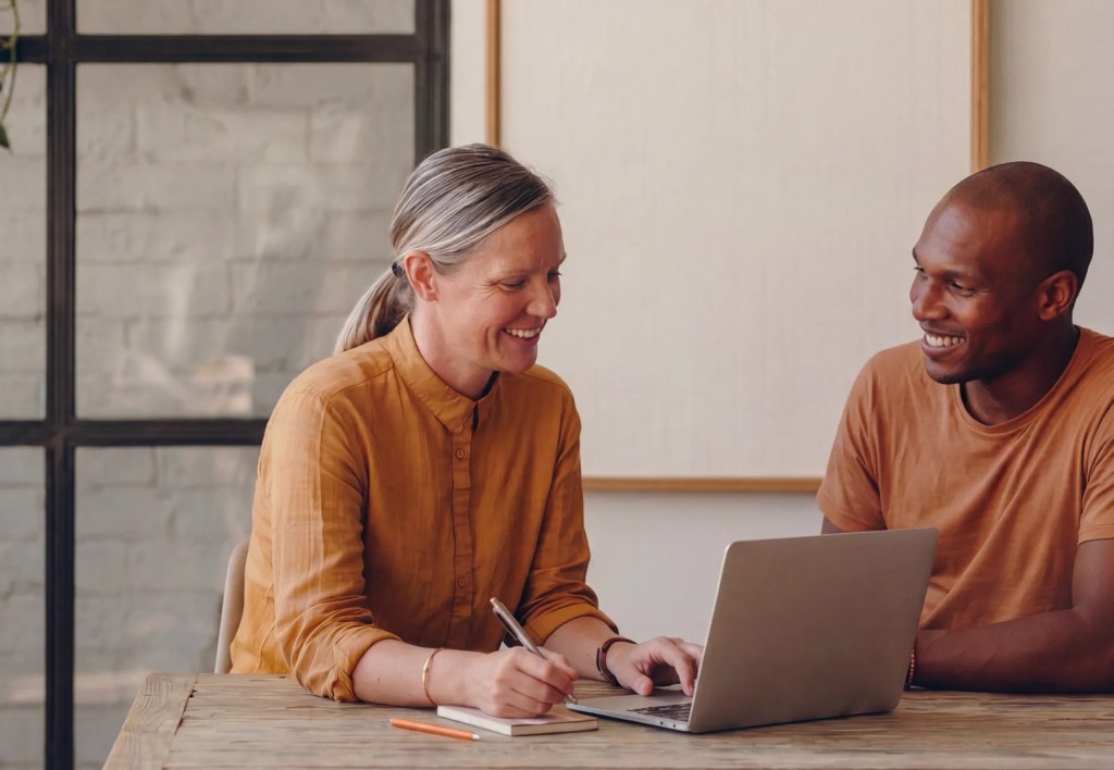 Two professionals collaborating over a laptop during a planning session with WordPress VIP service partners for an enterprise CMS implementation and systems integration project.