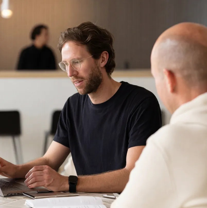 Person using a laptop during a meeting with a colleague.