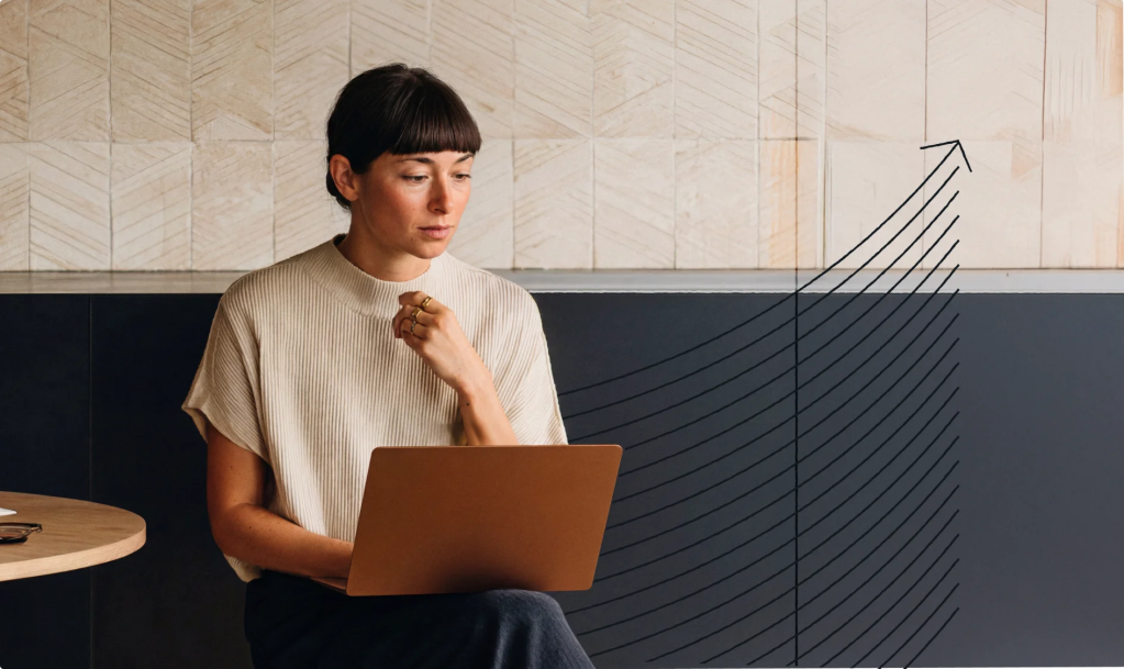 Person seated with a laptop, focused on their work, alongside an upward-trending graph illustration representing business growth, performance, and digital success.
