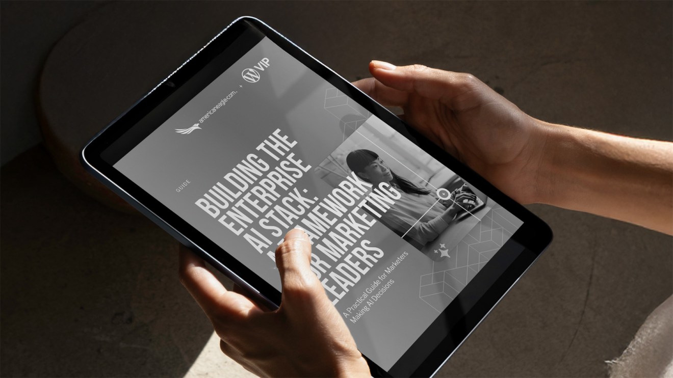 Person holding a tablet displaying a digital guide titled Building the Enterprise AI Stack for Marketing Leaders, an essential ai implementation guide for modern marketing teams.