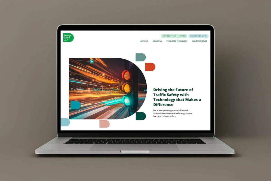 A laptop displays a website with a traffic light and motion blur, showing a traffic safety technology theme.