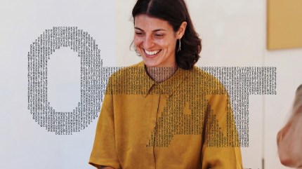 Smiling woman beside a key formed from letters, representing how structured, findable content supports AI search visibility.