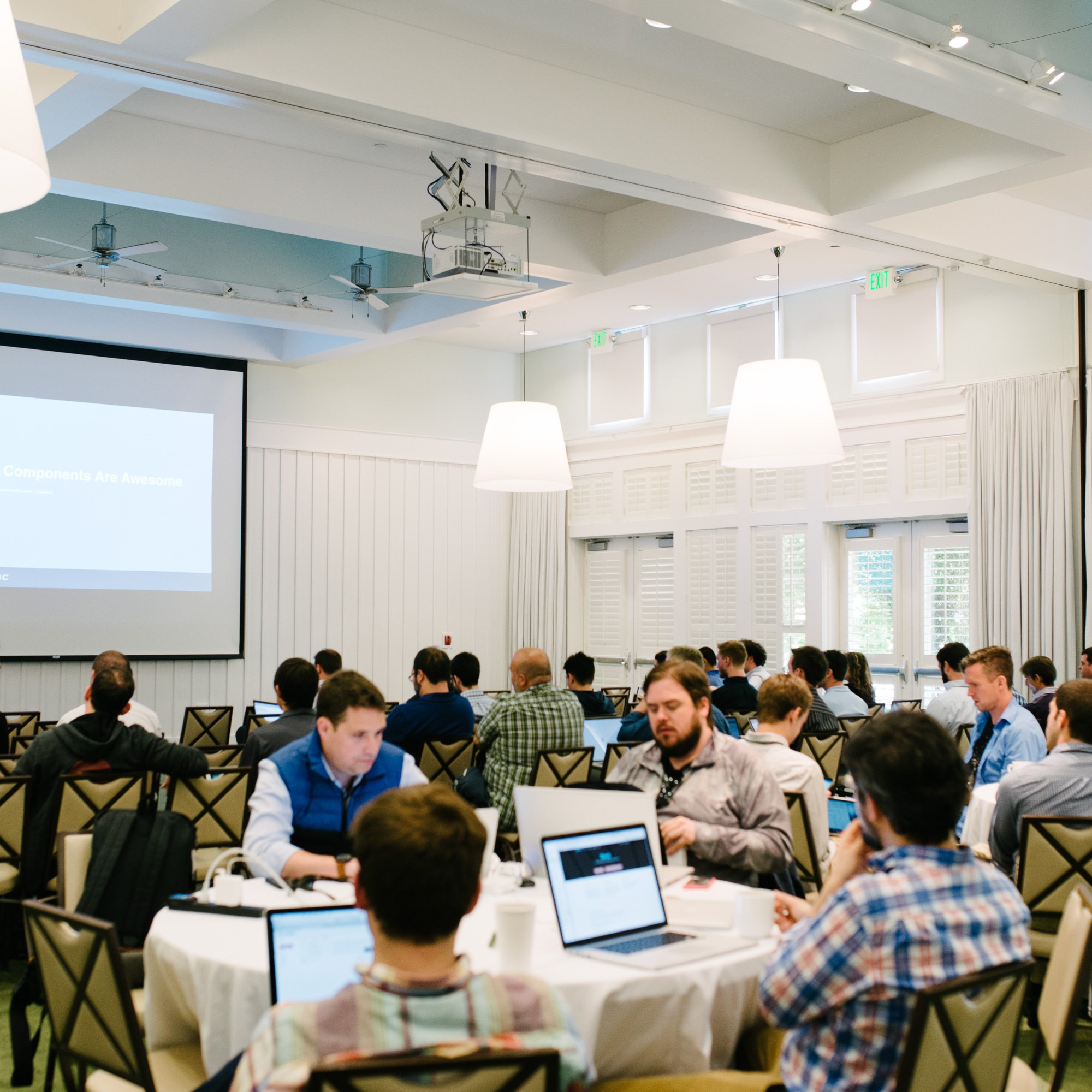 A room with people working at tables at a training session in Napa