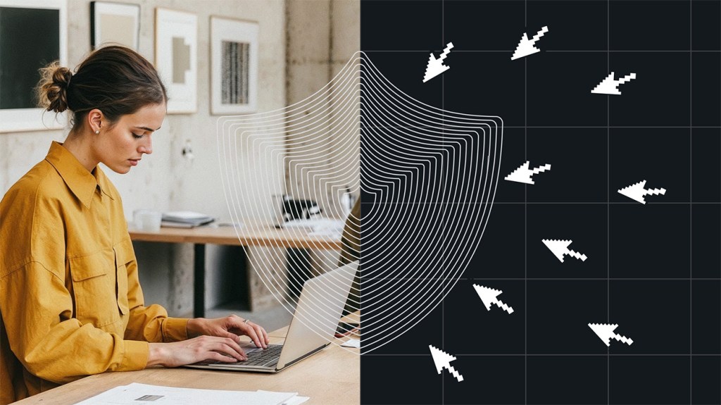 A woman in a mustard-colored shirt works on a laptop in a minimal office space. A stylized shield graphic overlays the image, dividing it in half—on the left, the woman is protected; on the right, digital arrow cursors attempt to breach the shield, symbolizing cybersecurity and protection from online threats.